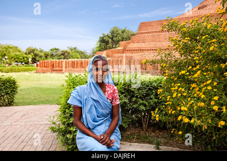 Porträt einer Frau sitzt neben einer Pflanze Chaukhandi Stupa, Sarnath, Varanasi, Uttar Pradesh, Indien Stockfoto