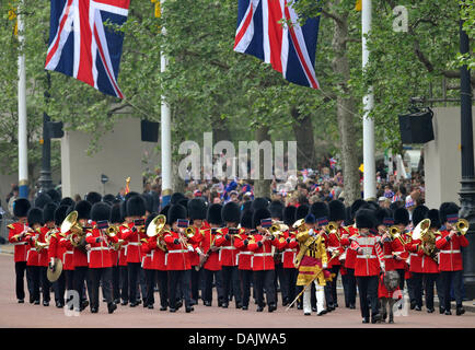 Eine Militärkapelle marschiert durch die Mall vor Prinz William und Catherine Middleton in einer Pferdekutsche von Westminster Abbey zum Buckingham Palace in London, Großbritannien, 29. April 2011 durchfahren. Die königliche Hochzeit soll von 2 Milliarden Zuschauern weltweit verfolgt werden. Foto: Peter Kneffel dpa Stockfoto