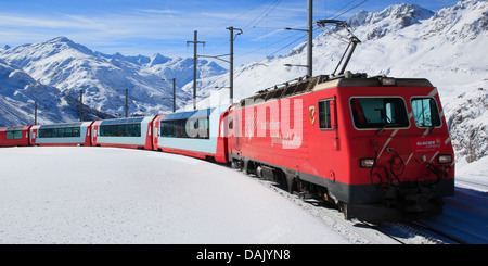 der Glacier Express in verschneite Bergpanorama, Schweiz, Andermatt Stockfoto