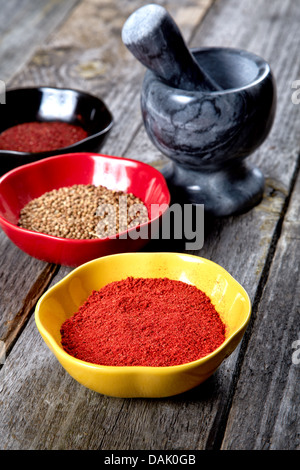 Gewürze und Mörser mit Stößel auf einem Tisch Stockfoto