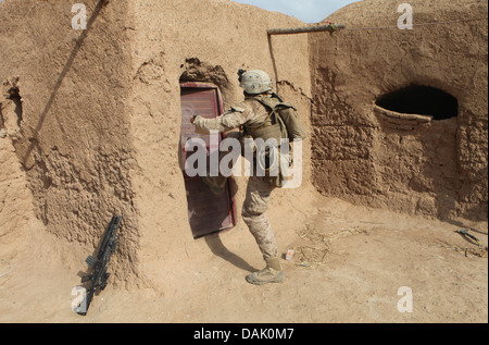 US Marine Lance Cpl. Christopher Ward tritt in eine verschlossene Tür bei einer Suche nach Aufständischen auf einem Gelände 30. Juni 2013 in der Provinz Helmand, Afghanistan. Stockfoto