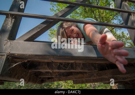 Frau auf der Brücke, die ihre Hand ausstrecken. Stockfoto