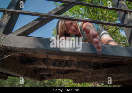 Frau auf der Brücke mit der ausgestreckten Hand. Stockfoto