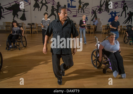 Eine afroamerikanische Tanzlehrer beauftragt, dass behinderte Erwachsene mit normalen Erwachsenen in San Diego, CA einen Rollstuhl-Tanz aufführen. Stockfoto