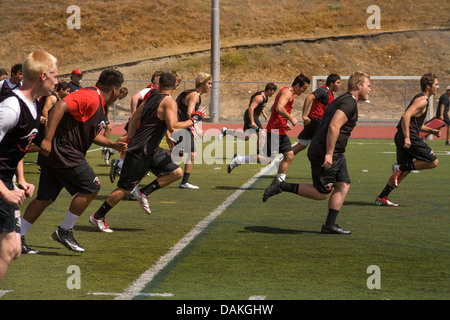 Multi-ethnischen Highschool-Athleten Protze mit Flexibilitätsübungen wie sie Frühjahr Fußballtraining in Kalifornien beginnen. Stockfoto