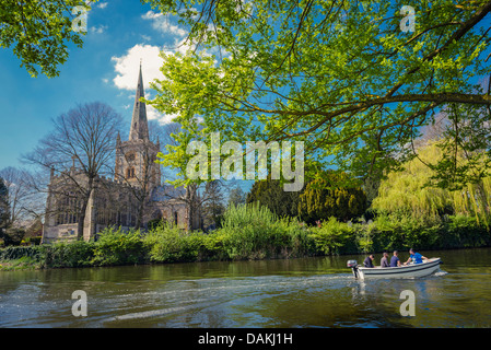 Ein Motorboot am Fluss Avon vor Dreifaltigkeitskirche an den Ufern des Flusses Avon in Stratford, Vereinigtes Königreich Stockfoto