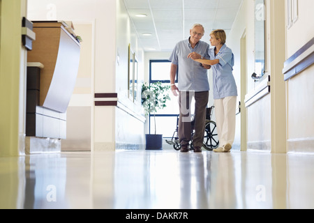 Krankenschwester helfen Patienten Spaziergang im Krankenhaus-Flur Stockfoto