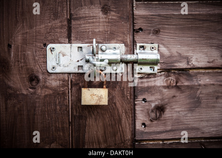 Rostige Sperre am Holztor Stockfoto