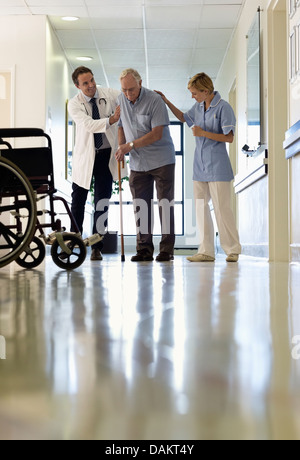 Arzt und Krankenschwester hilft älteren Patienten Spaziergang im Krankenhaus Stockfoto