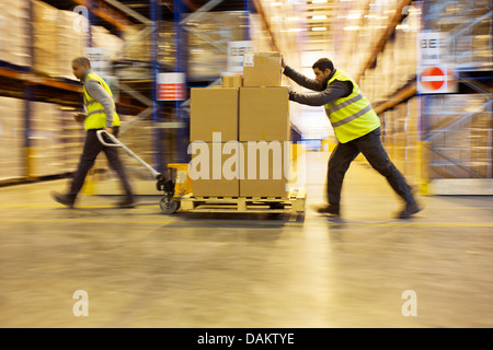 Arbeitnehmer, die Kart Kisten im Lager Stockfoto