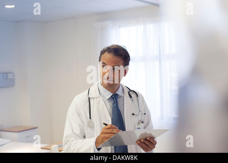 Arzt schriftlich auf Zwischenablage im Krankenhaus Stockfoto