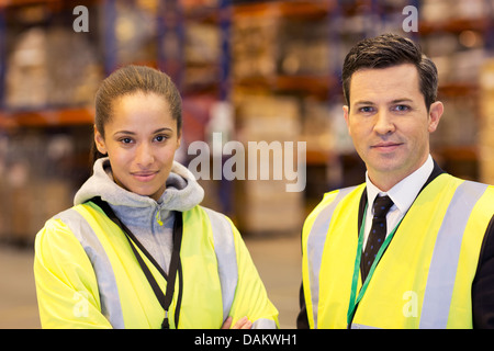 Unternehmer und Arbeitnehmer lächelnd in Lager Stockfoto