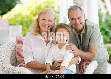 Älteres Ehepaar mit Enkelin auf Veranda Stockfoto