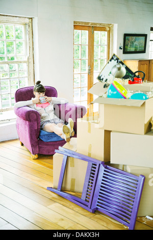 Frau trinkt Tee mit unverpackten Boxen Stockfoto