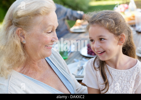 Ältere Frau mit Enkelin im Freien sitzen Stockfoto
