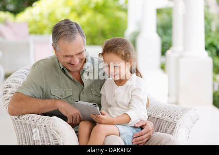 Älterer Mann und Enkelin mit Tablet-PC Stockfoto