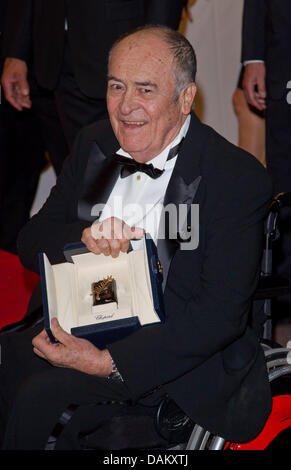 Regisseur Bernardo Bertolucci ankommen, zeigt seine ehrenamtlichen Goldene Palme während der 64. Internationalen Filmfestspiele im Agora in Cannes, Frankreich, am 11. Mai 2011. Foto: Hubert Boesl Stockfoto