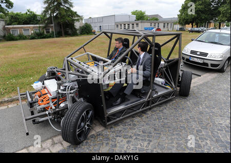 Forscher Markus Maurer (L) und Peter Bergmiller parken das Elektroauto "Mobile" auf dem Gelände der technischen Universität Braunschweig in Braunschweig, Deutschland, 26. Juni 2013. 'Mobile' ist mit seinen 600 PS eines der leistungsstärksten Elektro-Autos in der Welt. Es wird durch vier Motoren angetrieben. Foto: Peter Steffen Stockfoto