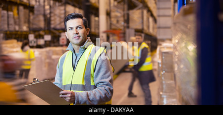 Arbeitnehmer über Zwischenablage in Lager Stockfoto