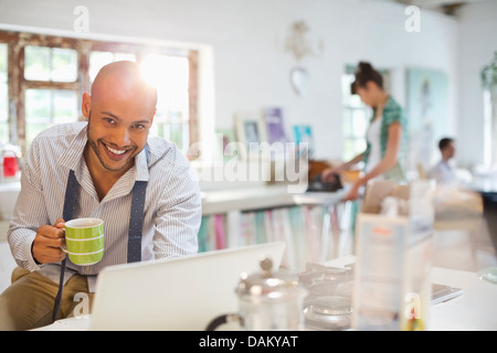 Geschäftsmann mit Laptop beim Frühstück Stockfoto