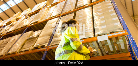 Arbeiter in Zwischenablage im Warehouse schreiben Stockfoto