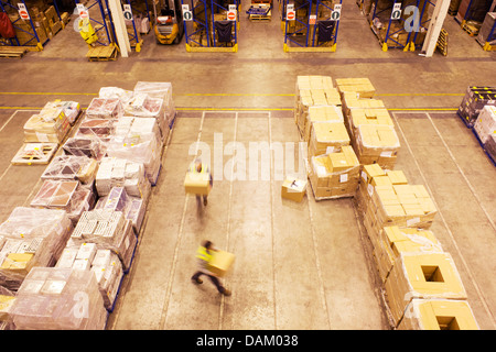 Verschwommene Sicht der Arbeitnehmer tragen Kisten im Lager Stockfoto