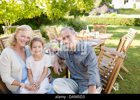 Älteres Paar und Enkelin lächelnd im freien Stockfoto
