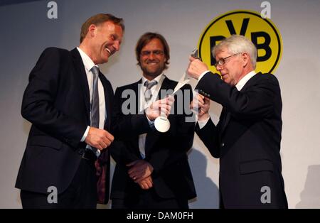 Borussia Dortmund Club CEO Hans-Joachim Watzke (L) erhält eine Medaille aus President Reinhard Rauball (R), während Trainer Juergen Klopp bei einem Abendessen nach dem Gewinn der deutschen Fußball-Bundesliga-Fußball-Meisterschaft in Dortmund 14. Mai 2011 schaut. Foto: Ina Fassbender dpa Stockfoto