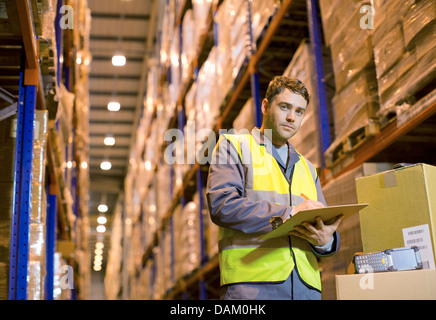 Arbeiter in Zwischenablage im Warehouse schreiben Stockfoto