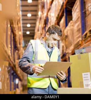 Arbeiter lesen Zwischenablage im Lager Stockfoto