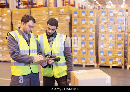 Arbeitnehmer schriftlich auf Zwischenablage im Lager Stockfoto