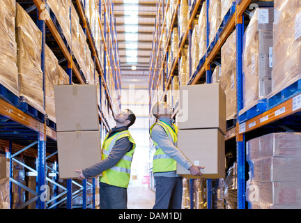 Arbeiter tragen Kisten im Lager Stockfoto