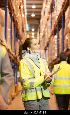 Arbeiter in Zwischenablage im Warehouse schreiben Stockfoto