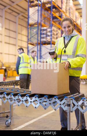 Arbeiter, die Scan-Feld auf Förderband im Lager Stockfoto