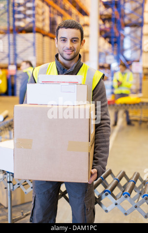 Arbeiter tragen Kisten im Lager Stockfoto