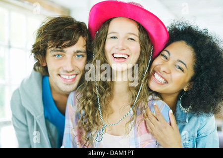 Freunde lächelnd zusammen drinnen Stockfoto