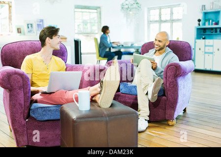 Männer, die gemeinsam im Wohnzimmer entspannen Stockfoto