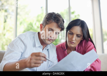 Paar Papiere zusammen auf dem Sofa lesen Stockfoto