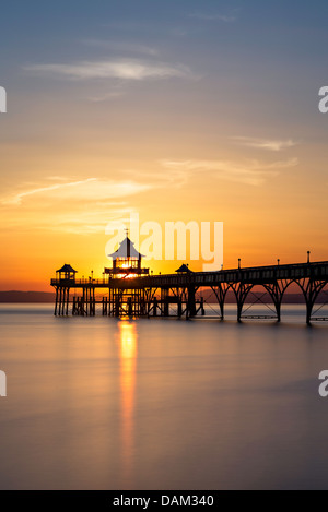 Clevedon Pier bei Sonnenuntergang. Die Sonne geht direkt hinter der Pavillon am Ende des Clevedon Pier und der Himmel dreht sich lebendige Farben Stockfoto