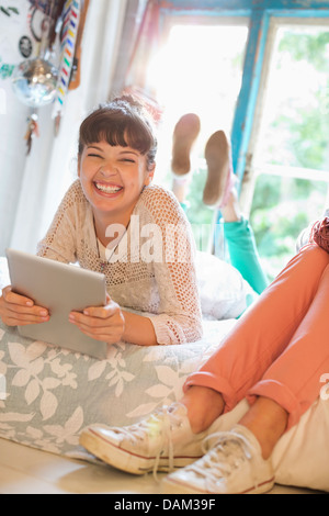 Frau mit Tablet-PC im Schlafzimmer Stockfoto