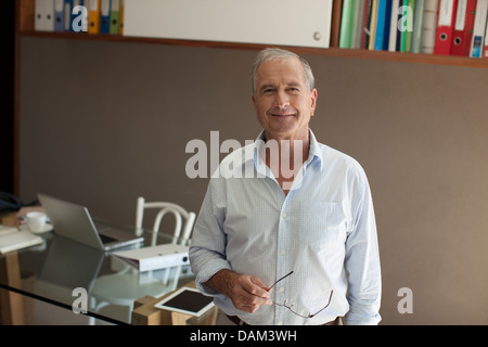 Älterer Mann lächelnd in Büro Stockfoto