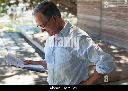 Geschäftsmann Lesung Papiere im freien Stockfoto