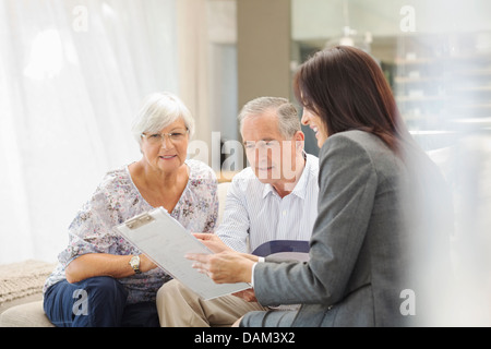 Finanzberater im Gespräch mit paar auf sofa Stockfoto
