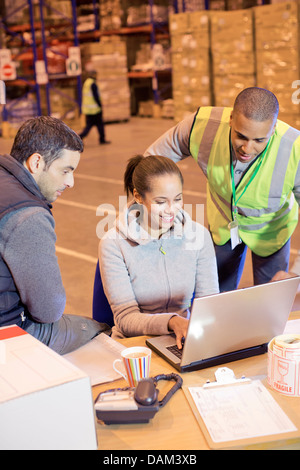 Arbeitnehmer mit Laptop im Lager Stockfoto