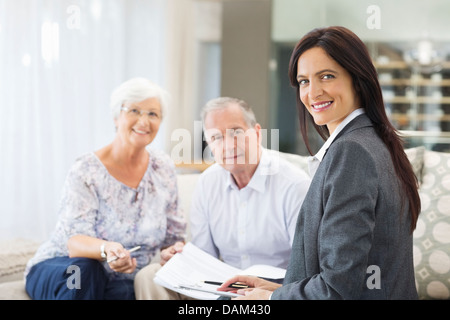 Finanzberater im Gespräch mit paar auf sofa Stockfoto