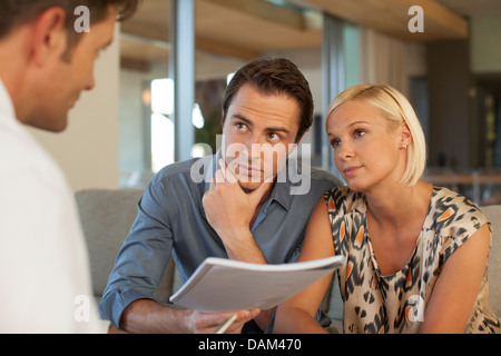 Finanzberater im Gespräch mit paar auf sofa Stockfoto
