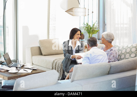 Finanzberater im Gespräch mit paar auf sofa Stockfoto