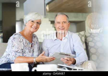 Älteres paar Lesung Zwischenablage auf sofa Stockfoto