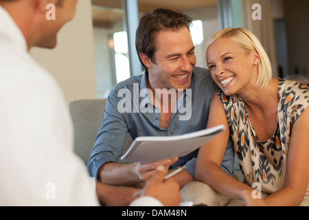 Finanzberater im Gespräch mit paar auf sofa Stockfoto