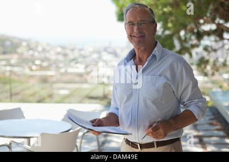 Ältere Mann Lesung Papiere im freien Stockfoto